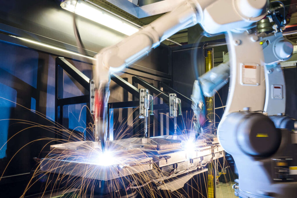 Welding robot producing sparks in an industrial cell